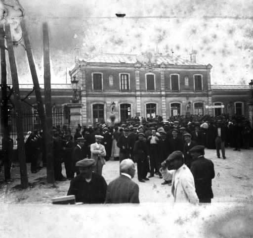 Rassemblement devant la gare (vue 1) et devant la librairie du Pont-Neuf (faisant le coin avec le quai Victor Hugo, vue 2) en attendant les dépêches des gros titres des événements des 28 et 29 juillet 1914 (vues 3-4).